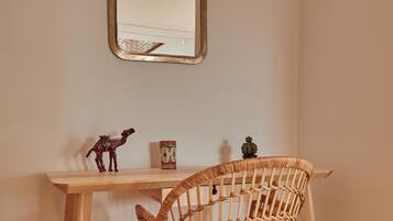 A corner desk with a woven chair, a small figurine, and a decorative item on the wall.