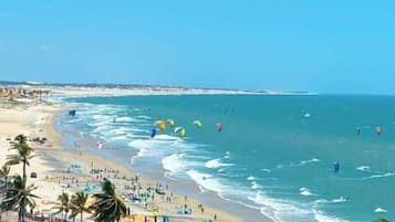 Una playa cerca, arena blanca, sillas reclinables de playa, sombrillas