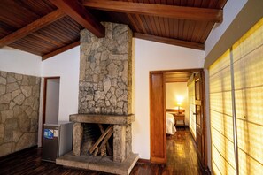 A traditional stone fireplace with a wooden mantel, a built-in heater, and a wooden floor. - REAL HOTEL MONTERREY (Independencia)