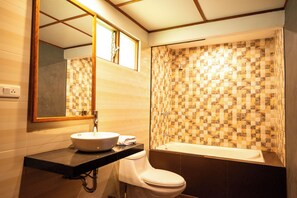 Bañera con ducha, toallas, jabón, shampoo