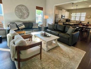 Relax in this stylish living room with a sofa set, armchair, and coffee table, surrounded by a world map and a patterned rug.