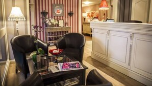 A modern hotel room with a dining area, striped wallpaper, and a white cabinet. - Le Cottage Hotel (Bruay-la-Buissiere)
