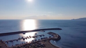 A coastal marina with boats docked, a pier, and a clear sky. - ML in sea promenade (Chiavari)