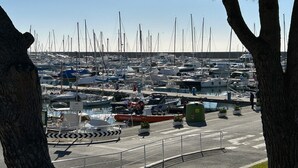 A marina with numerous boats docked, a lifeboat, and a small boat with people on board. - ML in sea promenade (Chiavari)