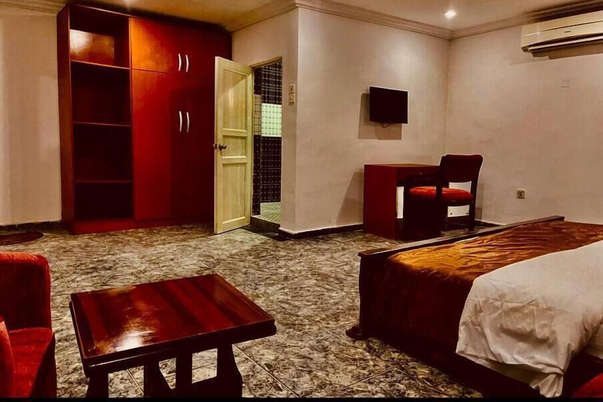Une chambre avec un lit, un bureau, une chaise et une armoire.