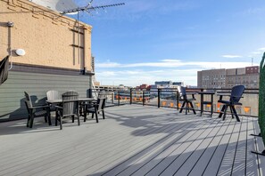 Eine Dachterrasse mit Sitzgelegenheiten und Blick auf die Stadt.