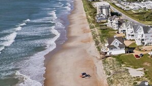 An aerial view of a beach with houses along the shore.