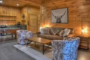 A cozy room with a pool table, a sofa, and a coffee table.