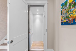 A hallway with a white door leading to a room with a wooden floor. - A Weekend at Billys: 5 Bedrooms, Private Pool, Pet Friendly, Plantation! (St. George Island)