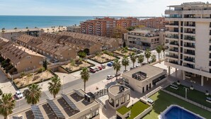 A coastal residential area with apartment buildings, a swimming pool, and solar panels. - Patacona Sunrise Duplex I. Wifi + parking + pool + paddle (Alboraya)