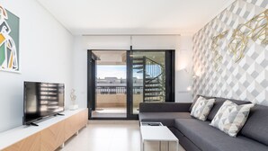 A modern living room with a flat-screen TV, a sofa, and a coffee table. - Patacona Sunrise Duplex I. Wifi + parking + pool + paddle (Alboraya)