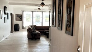 A spacious living room with a brown sofa, a coffee table, and a ceiling fan. - SERENITY AWAITS HILL WINE Co#2 (Temecula)