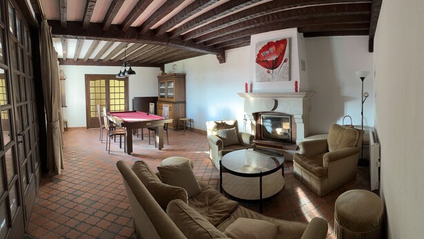 Una sala de estar acogedora con chimenea, asientos cómodos y un comedor.