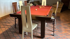 Una mesa de billar con sillas, una chimenea y un suelo con diseño.