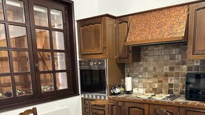 Una cocina con armarios de madera, una estufa y una mesa de comedor con sillas.