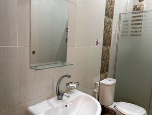 A bathroom with a white sink, mirror, and toilet. - Royal city hotel  (Cairo)