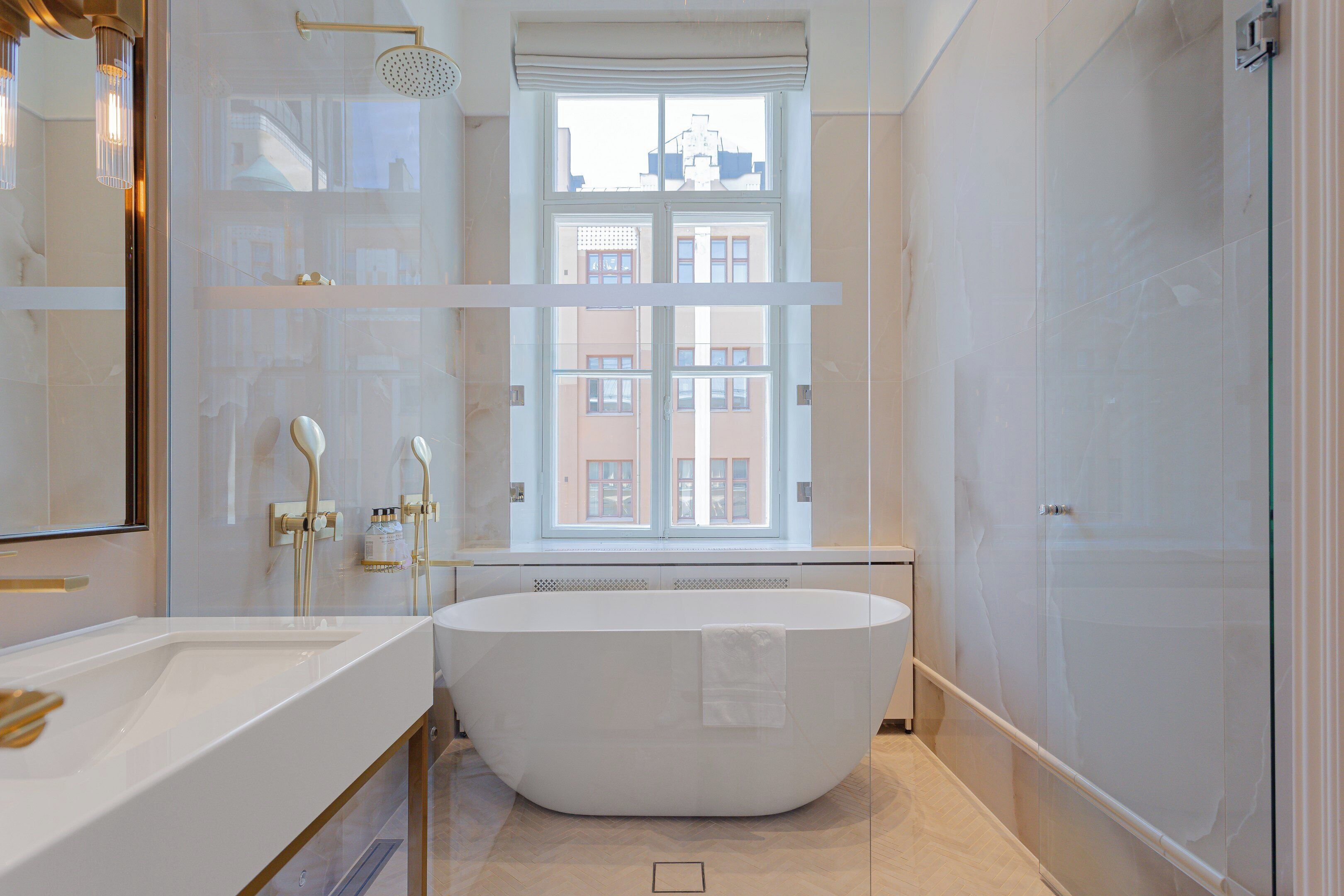 A modern bathroom with a freestanding bathtub, a large mirror, and a glass-enclosed shower.