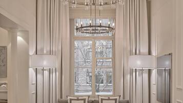 A spacious living room with a large chandelier, a sofa set, and a television.