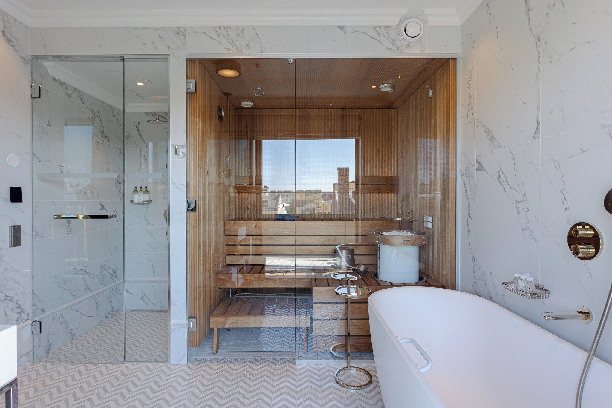 A modern bathroom with a glass-enclosed shower, a wooden vanity, and a large bathtub.