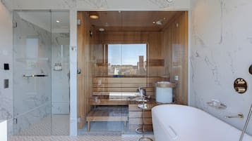 A modern bathroom with a glass-enclosed shower, a wooden vanity, and a large bathtub.