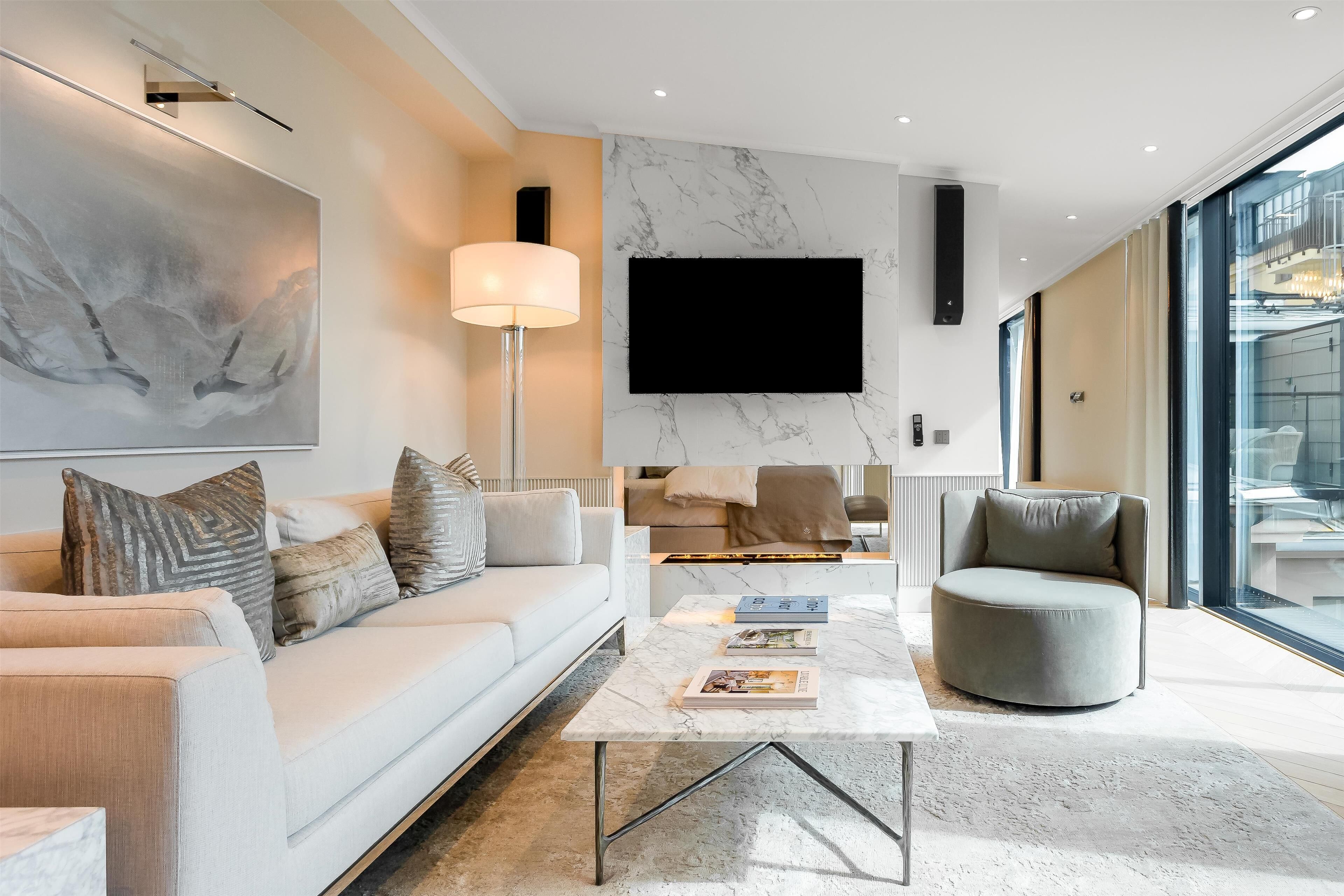 A modern living room with a sofa, coffee table, and a television mounted on the wall.