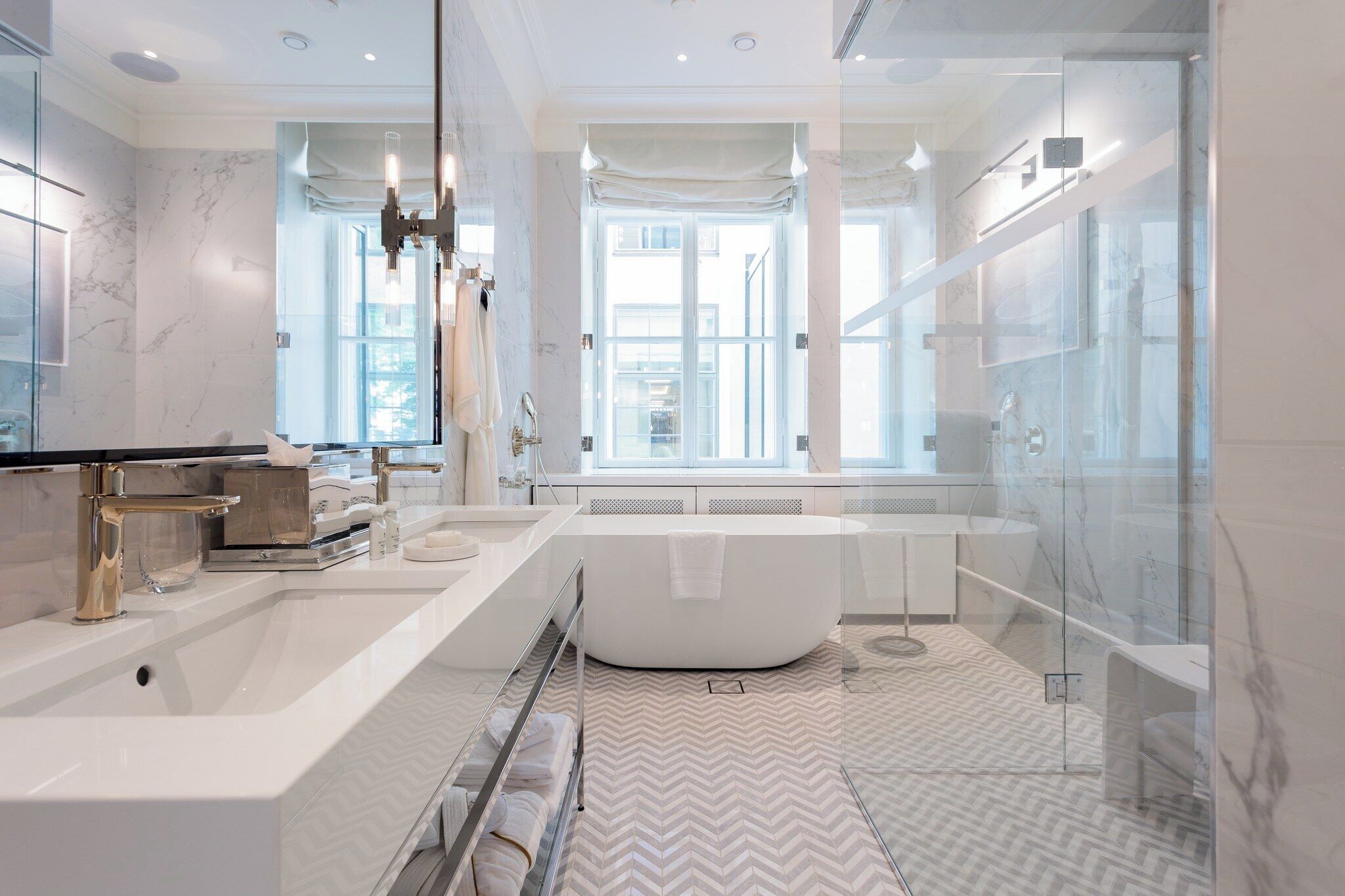 A modern bathroom with a large bathtub, a glass shower enclosure, and a vanity with a mirror.