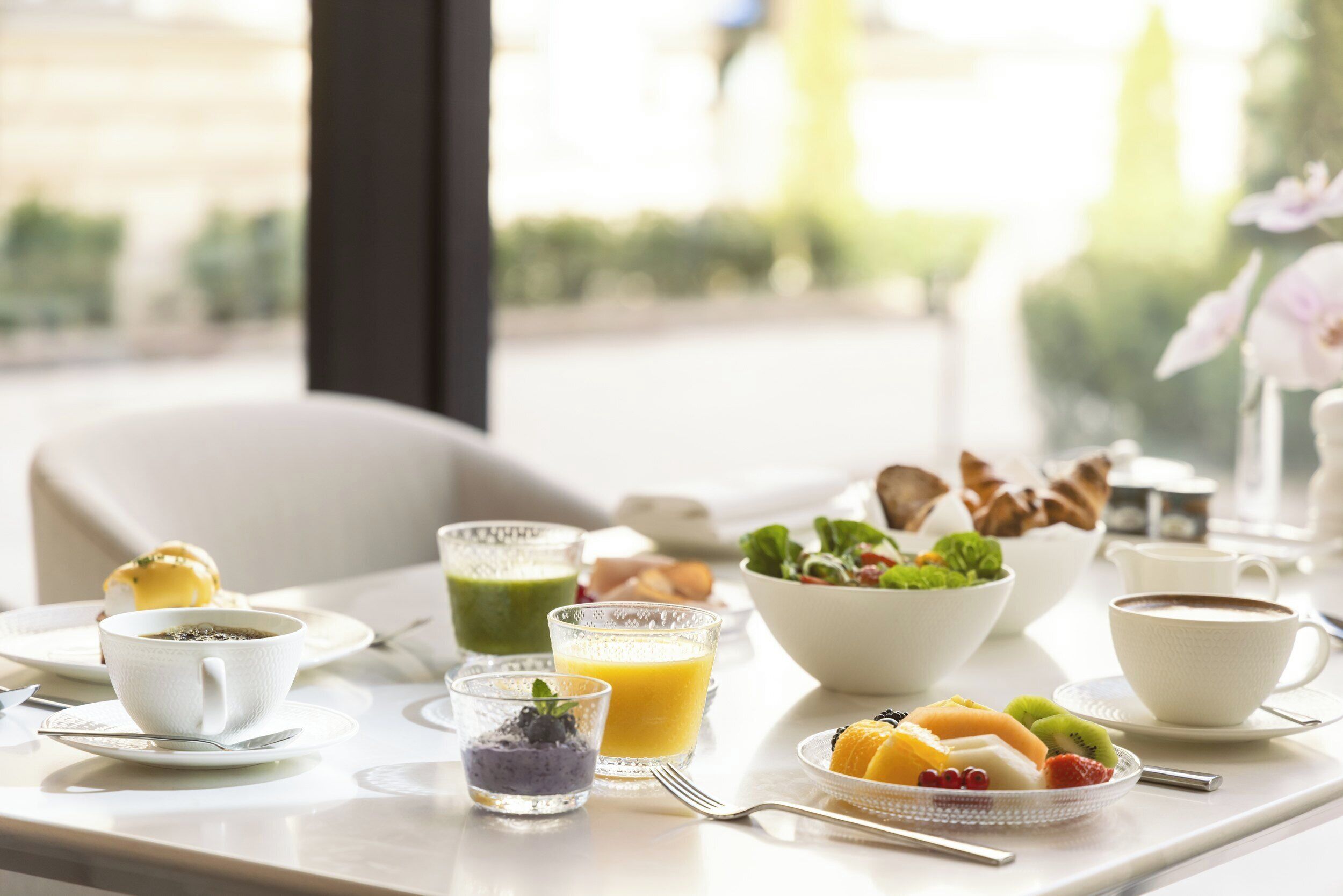 A breakfast setting with a variety of food items and drinks on a table.