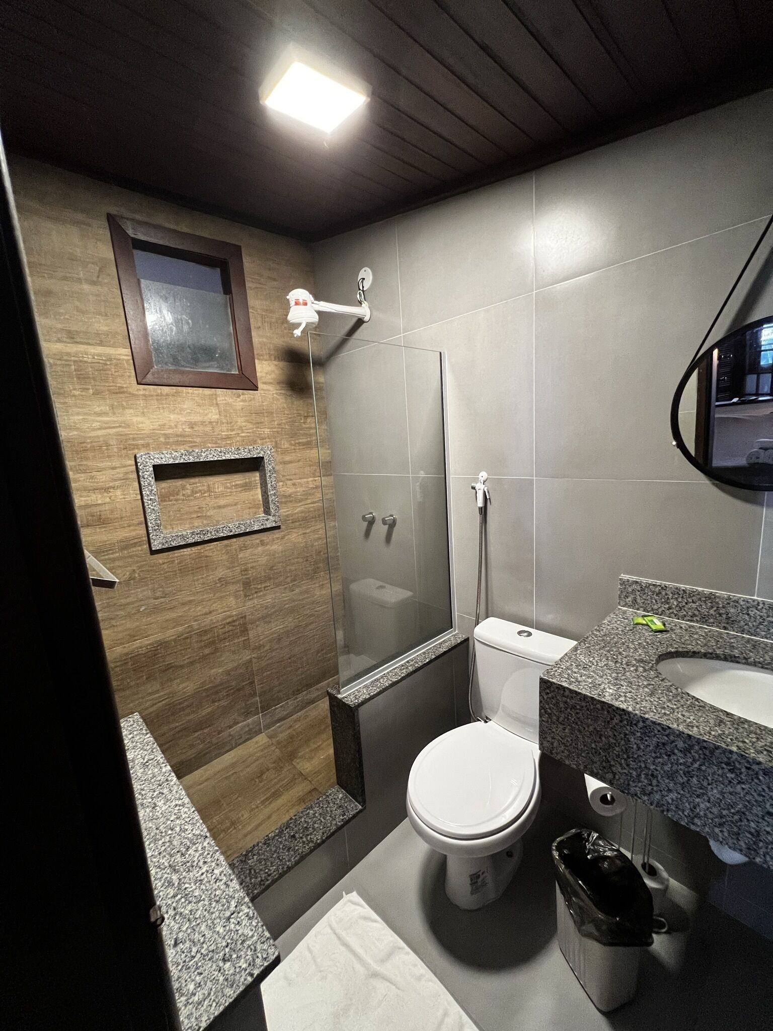 Een moderne badkamer met douche, toilet en wastafel.
