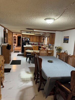 A spacious kitchen with wooden cabinets, a dining area with a table and chairs, and a view of the living room.