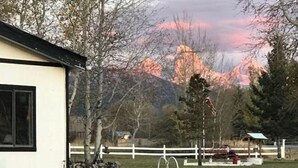 A small, single-story building with a white exterior and a black window frame. - Pert-Nere-A-Ranch Hot Tub Teton Views Getaway! (Tetonia)