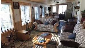 A cozy living room with patterned sofas, a coffee table, and a bicycle. - Pert-Nere-A-Ranch Hot Tub Teton Views Getaway! (Tetonia)