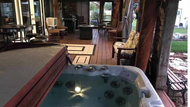 A hot tub on a wooden deck with outdoor furniture and a covered patio area. - Pert-Nere-A-Ranch Hot Tub Teton Views Getaway! (Tetonia)