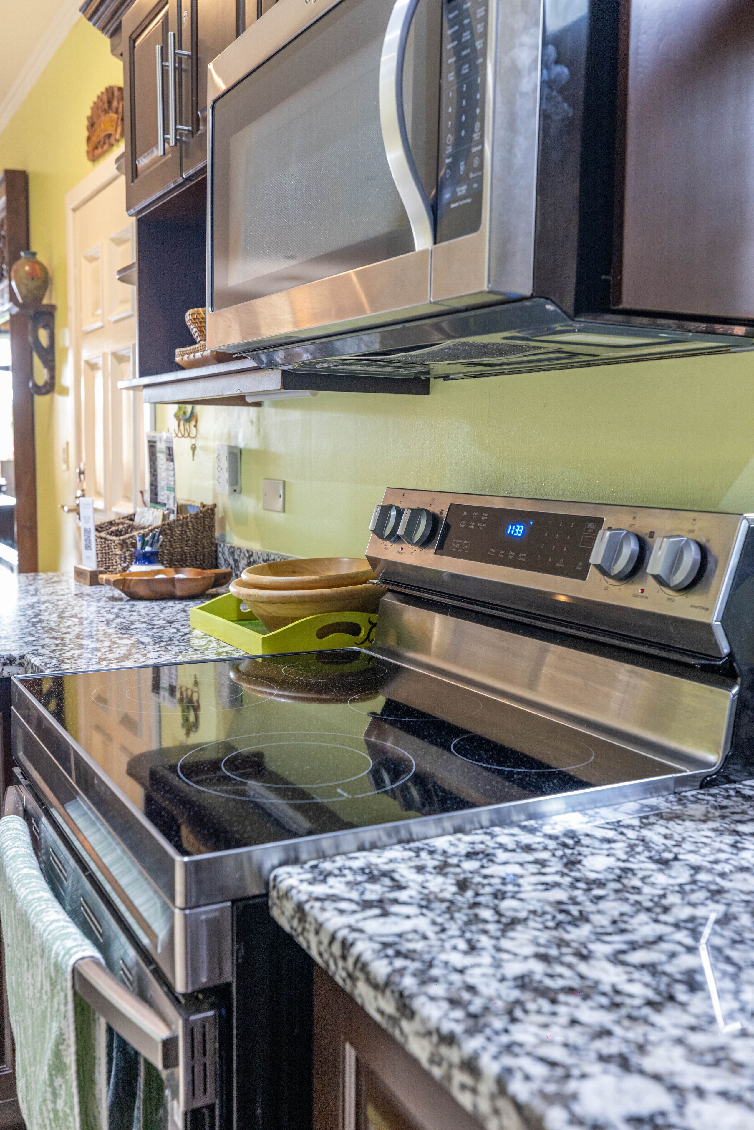 A kitchen with stainless steel appliances, granite countertops, and wooden cabinets.