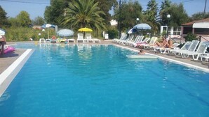A swimming pool with lounge chairs and umbrellas.