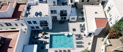 Una piscina al aire libre de temporada, sombrillas