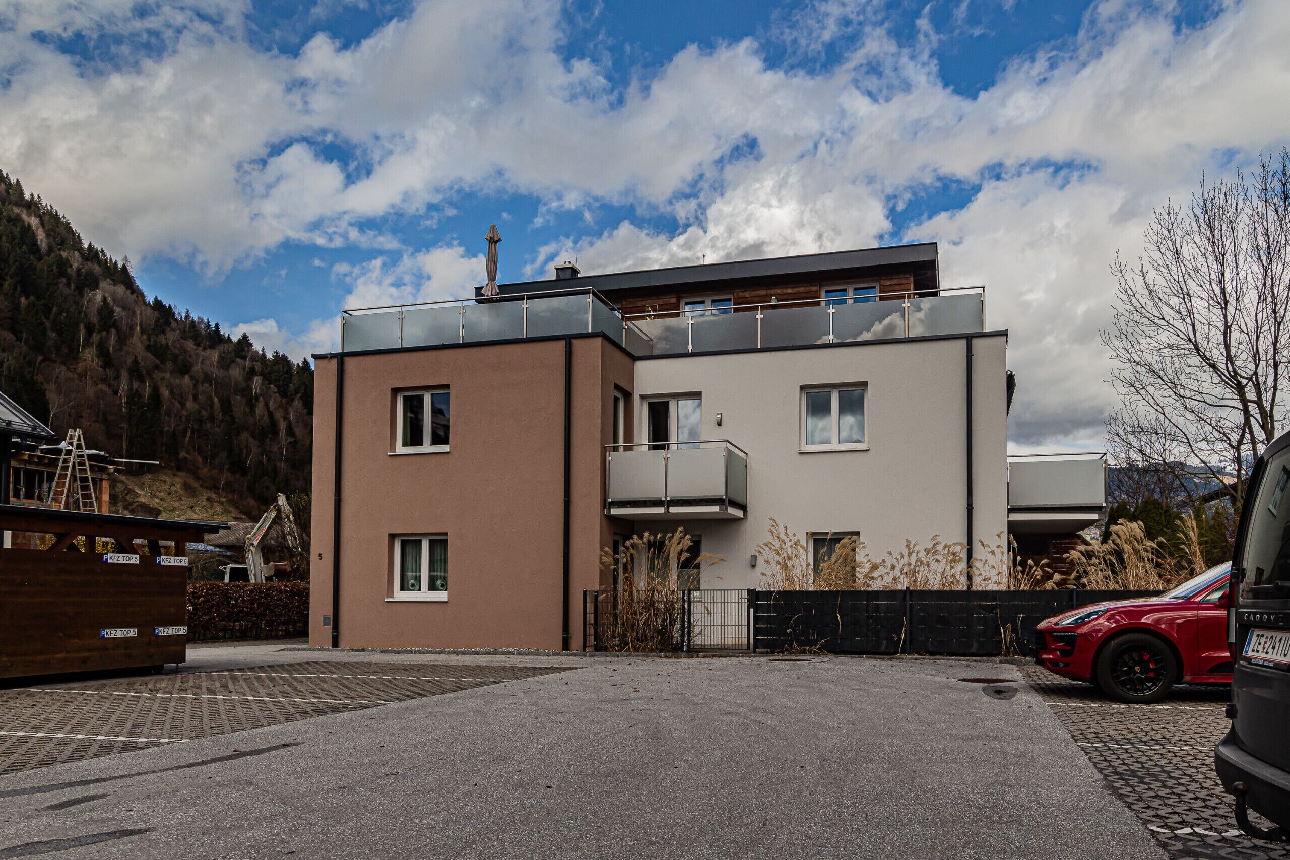 A modern two-story building with a flat roof and a balcony.