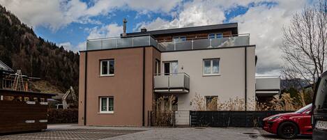 A modern two-story building with a flat roof and a balcony.