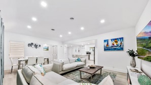 A modern living room with a sofa, coffee table, and artwork on the wall. - The perfect Vacation next to the Ocean in the heart of Fort Lauderdale Beach. (Fort Lauderdale)