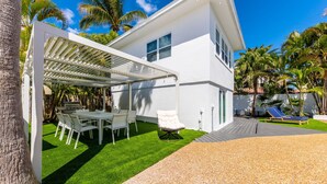 A modern house with a covered patio, a lawn, and a pool area. - The perfect Vacation next to the Ocean in the heart of Fort Lauderdale Beach. (Fort Lauderdale)
