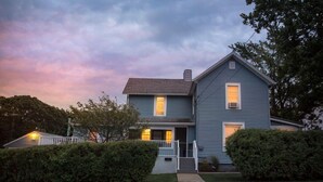 A two-story house with a front porch, a chimney, and a well-maintained lawn. - Just a few blocks from Lake Erie!  4 season home with a cozy cottagey feel. (Lakeside Marblehead)