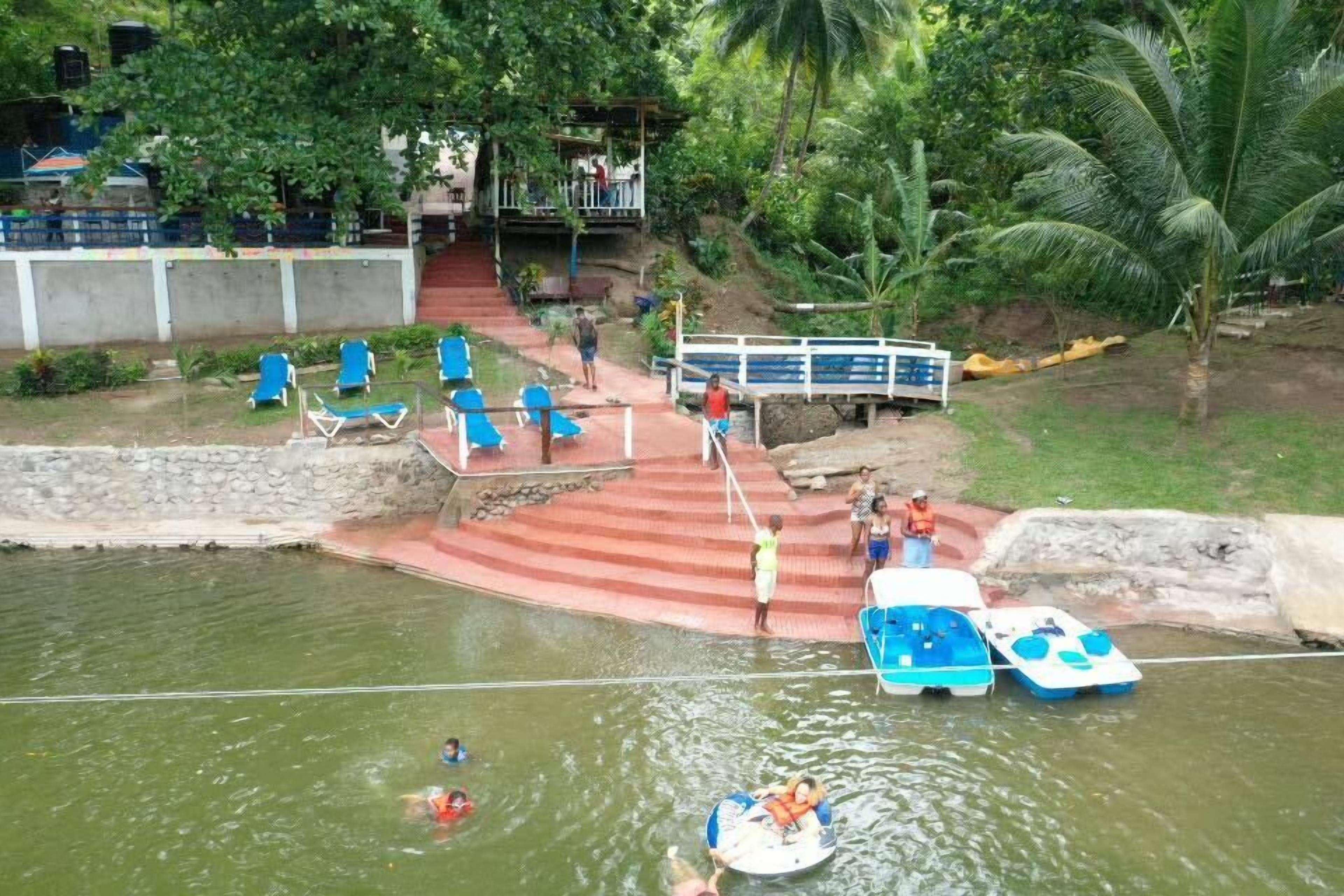 Un parc aquatique doté d’une piscine, de chaises longues et d’un espace de location de bateaux.