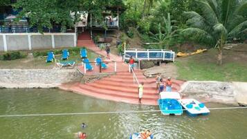 Un parc aquatique doté d’une piscine, de chaises longues et d’un espace de location de bateaux.