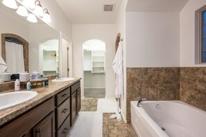Un bagno con un lavandino ampio, una vasca da bagno e un cabina armadio.