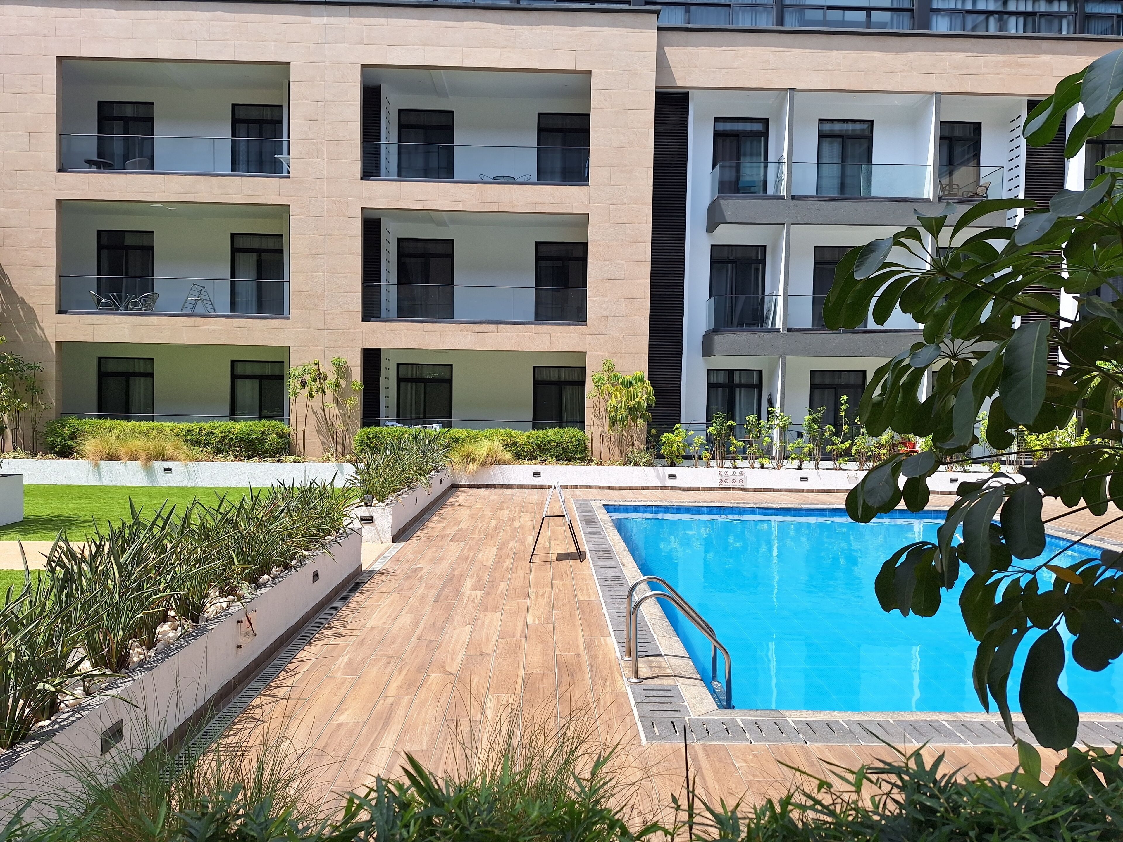 Un edificio moderno con numerosi balconi e una piscina.