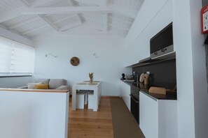 A compact living space with a kitchenette, a dining area, and a sofa.