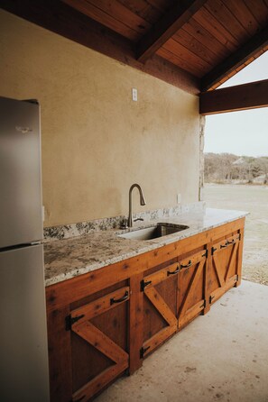 A kitchen with a built-in sink, wooden cabinets, and a refrigerator. - River Front Property (Concan)