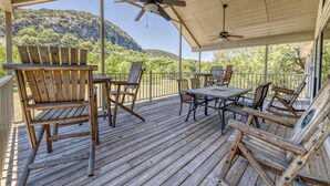 A wooden deck with outdoor furniture, a ceiling fan, and a view of a mountainous landscape. - Large river front home in Cypress Bend (Concan)