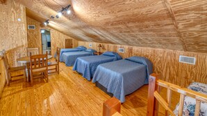 A wooden interior with three beds, a table, and chairs. - Beautiful home in the Comanche Crossing Subdivision (Concan)