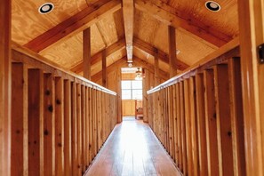 A wooden hallway with a high ceiling and a central window. - River Front in Comanche Crossing (Concan)