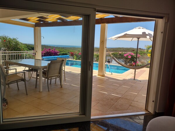 A patio with a pool, outdoor furniture, and a view of the landscape.